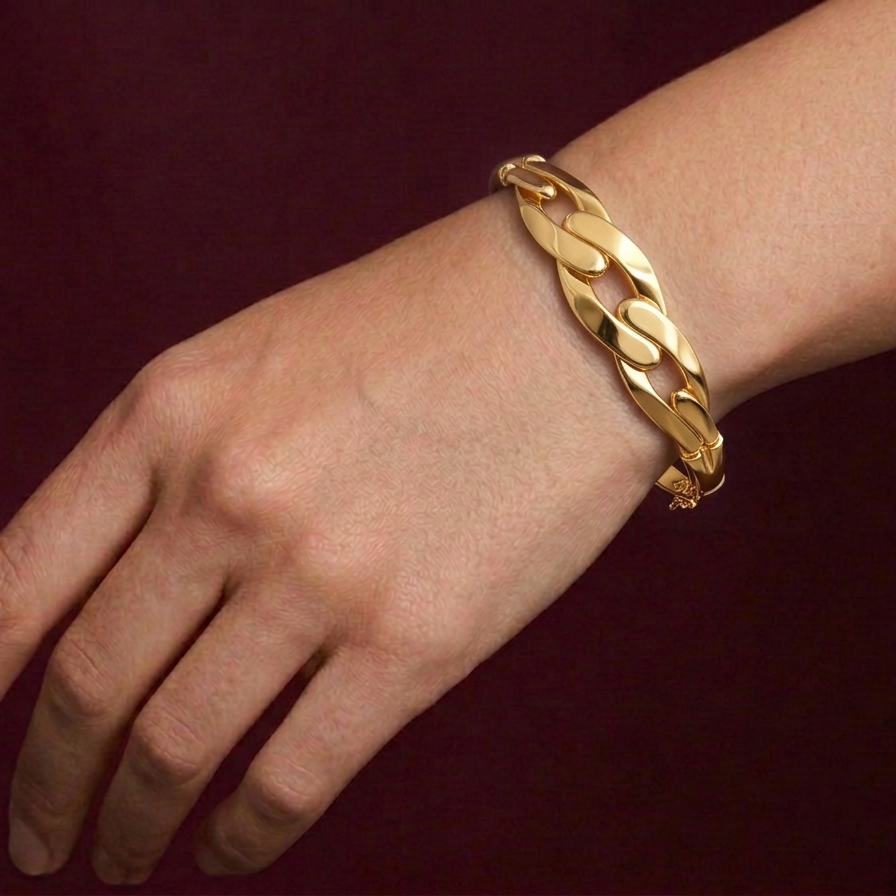 Gold butterfly bracelet on a wrist against a dark background