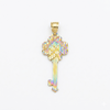 Gold key-shaped pendant with iridescent design on a white background