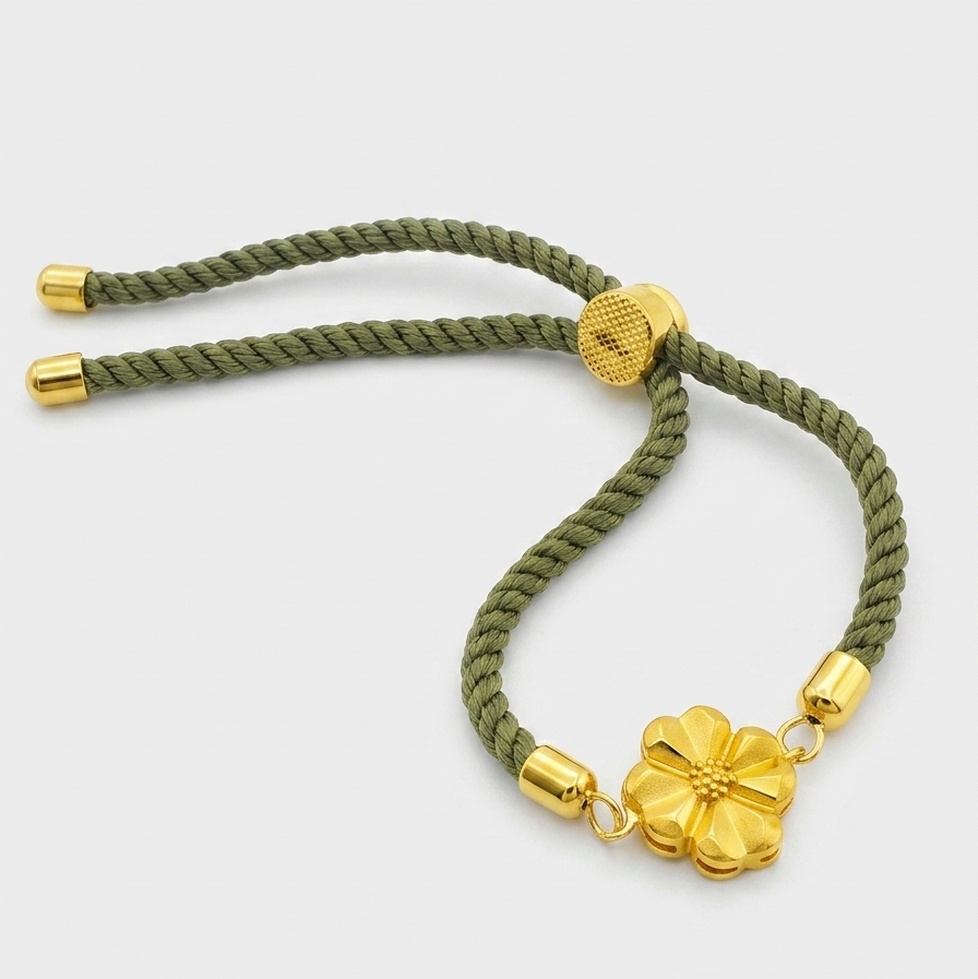 Green braided bracelet with gold accents on a white background
