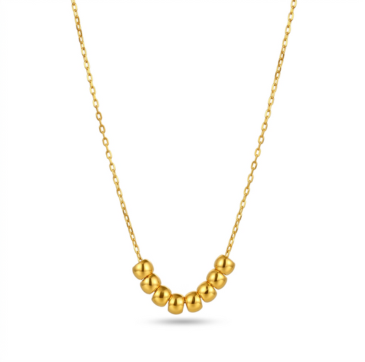 Gold necklace with round beads on a white background
