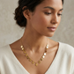 Woman wearing a gold necklace against a neutral background