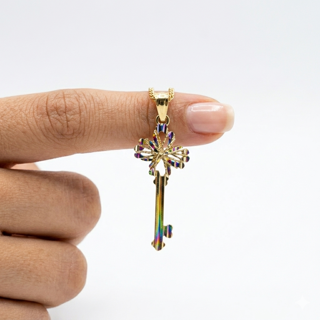 Gold key-shaped pendant with colorful accents held between fingers against a white background