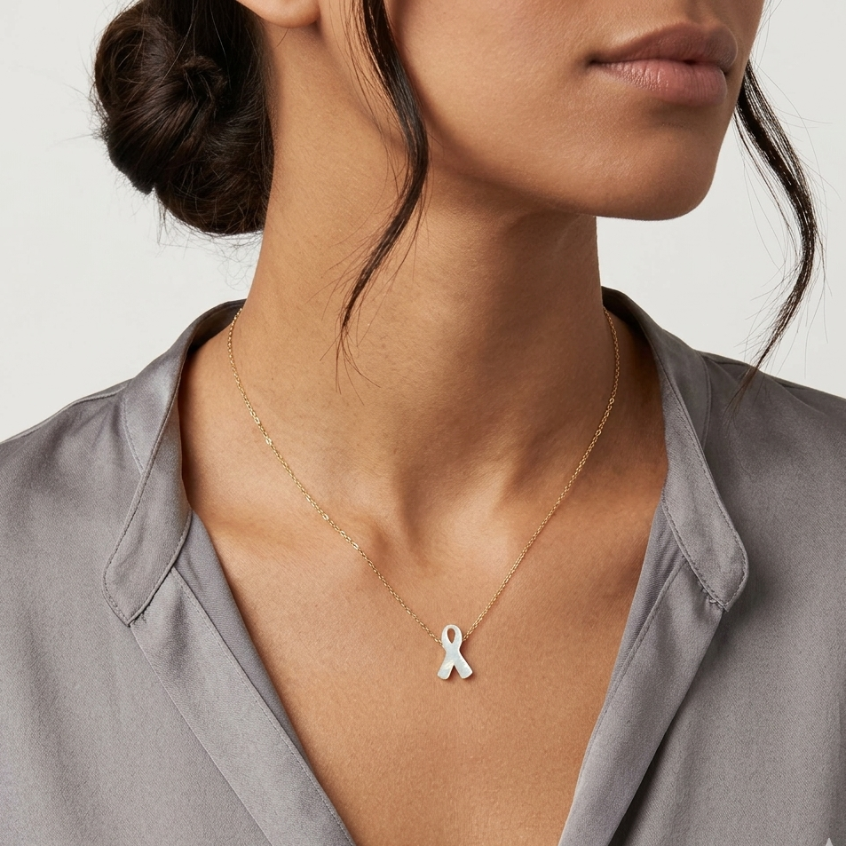 Woman wearing a silver necklace with a white ribbon pendant on a neutral background