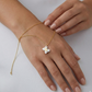 Gold bracelet with a star-shaped pendant on a hand against a white background