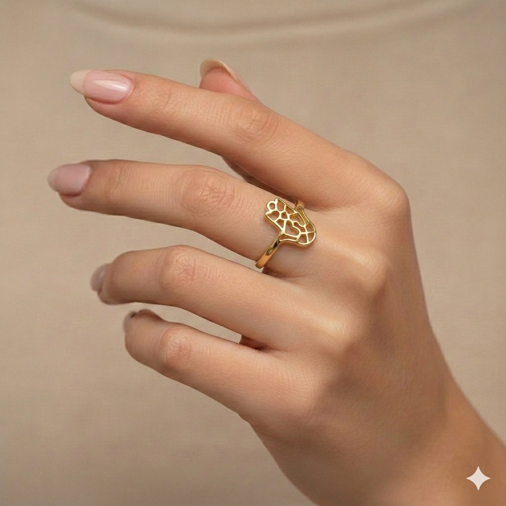 Gold ring on a hand against a beige background