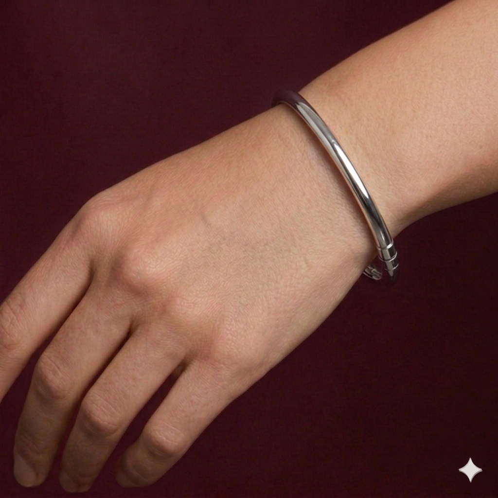 Silver bracelet on a wrist against a dark red background