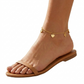 Brown sandal worn on a foot with a gold anklet featuring heart-shaped charms against a white background