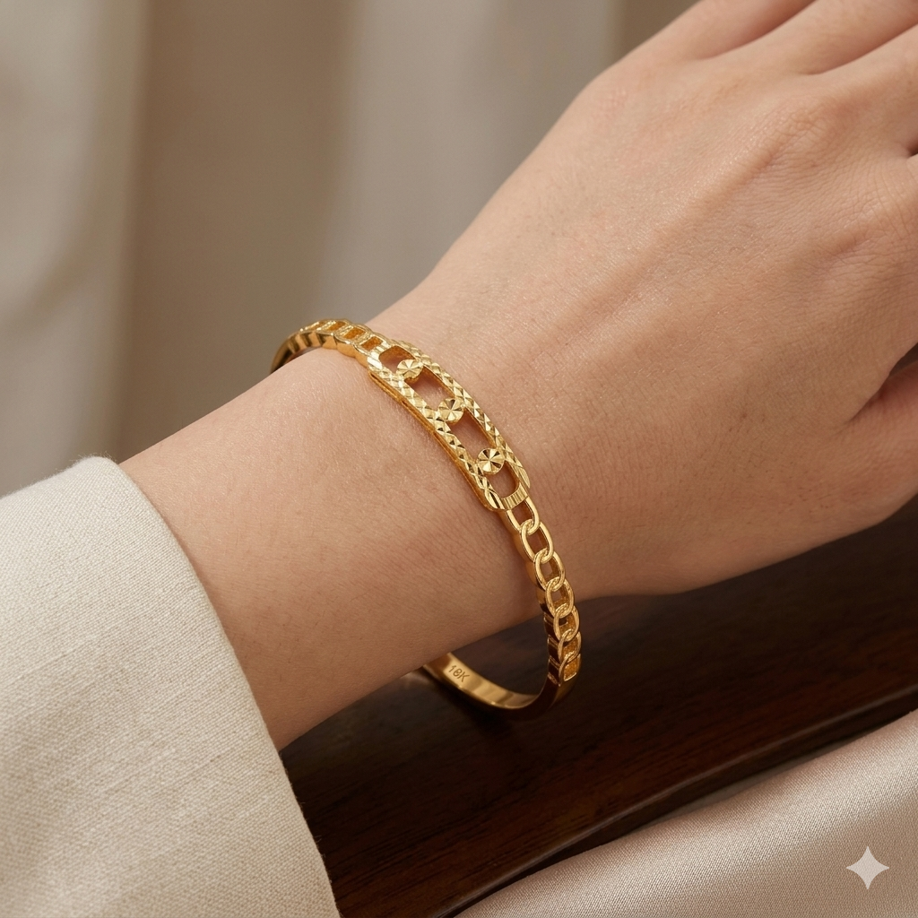 Gold chain bracelet on a wrist with a neutral background