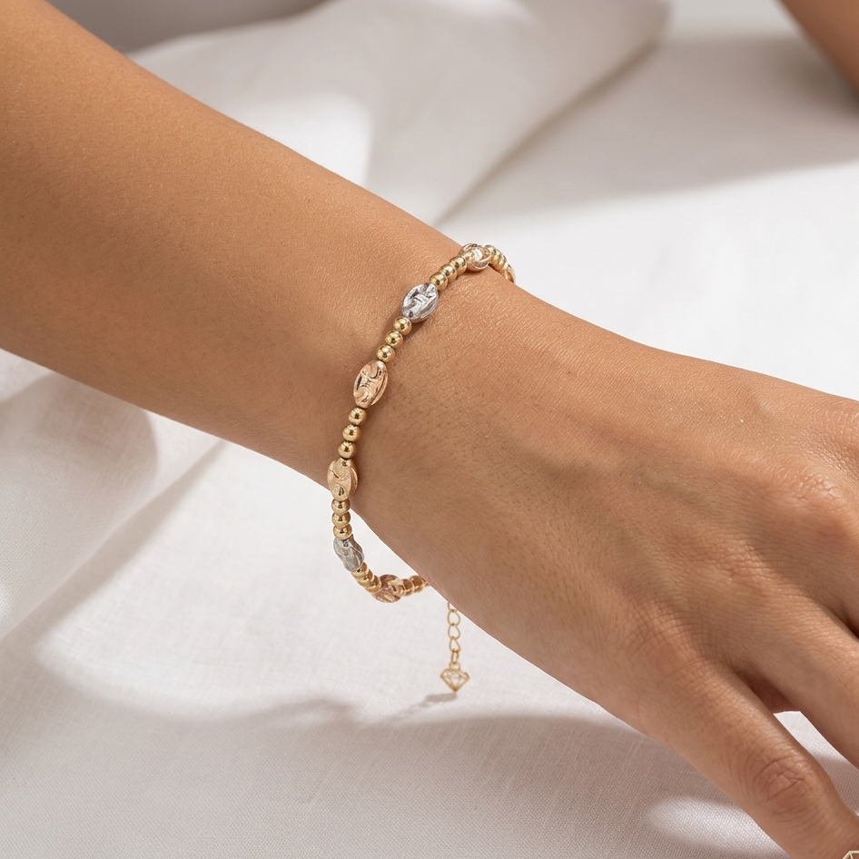 Gold bracelet on a person's wrist against a white background