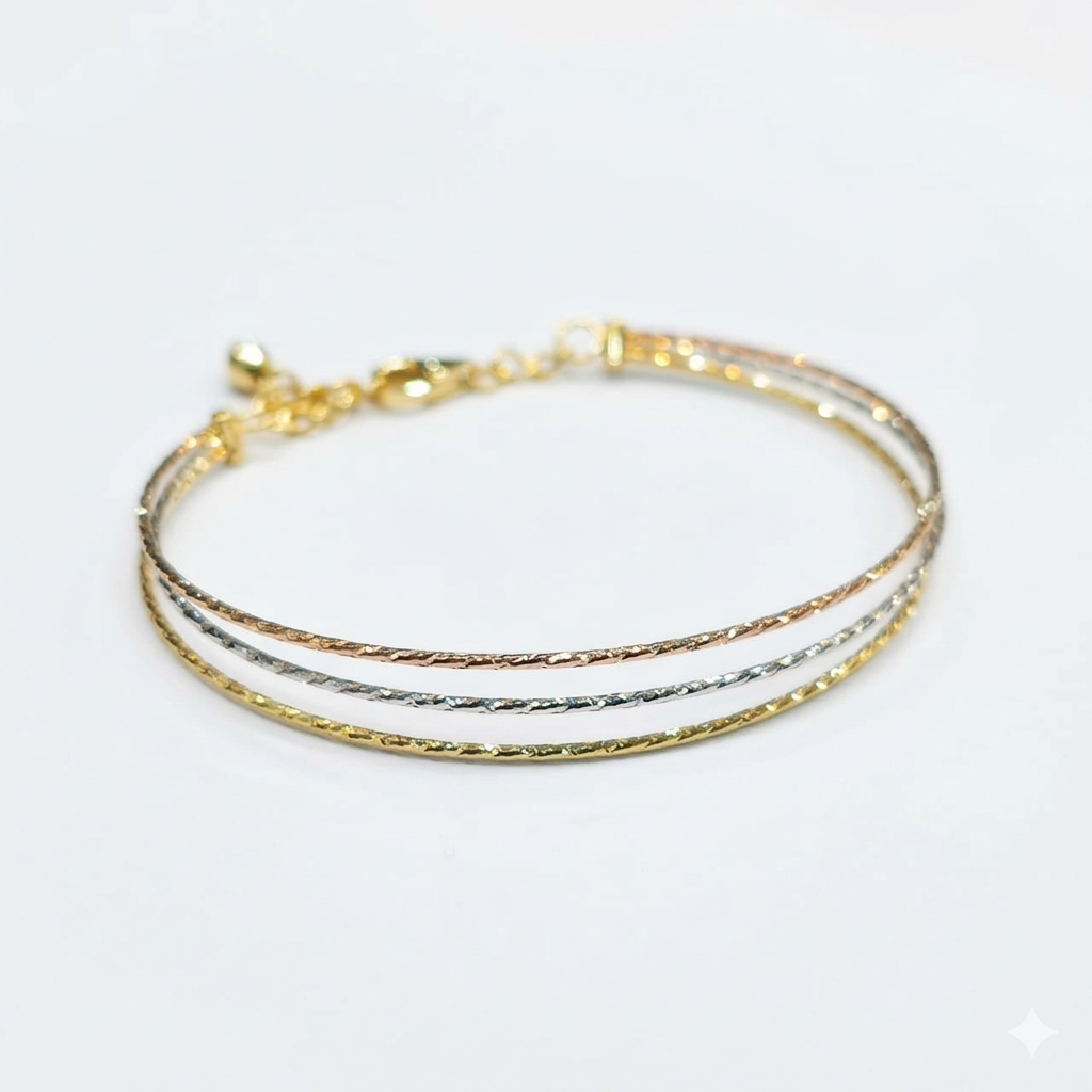Three gold bracelets stacked on a white background