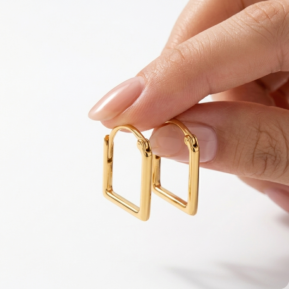 Gold ring with a unique design held by a hand on a white background