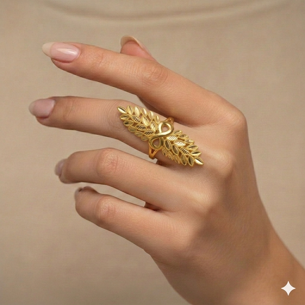 Gold leaf ring on a hand against a beige background