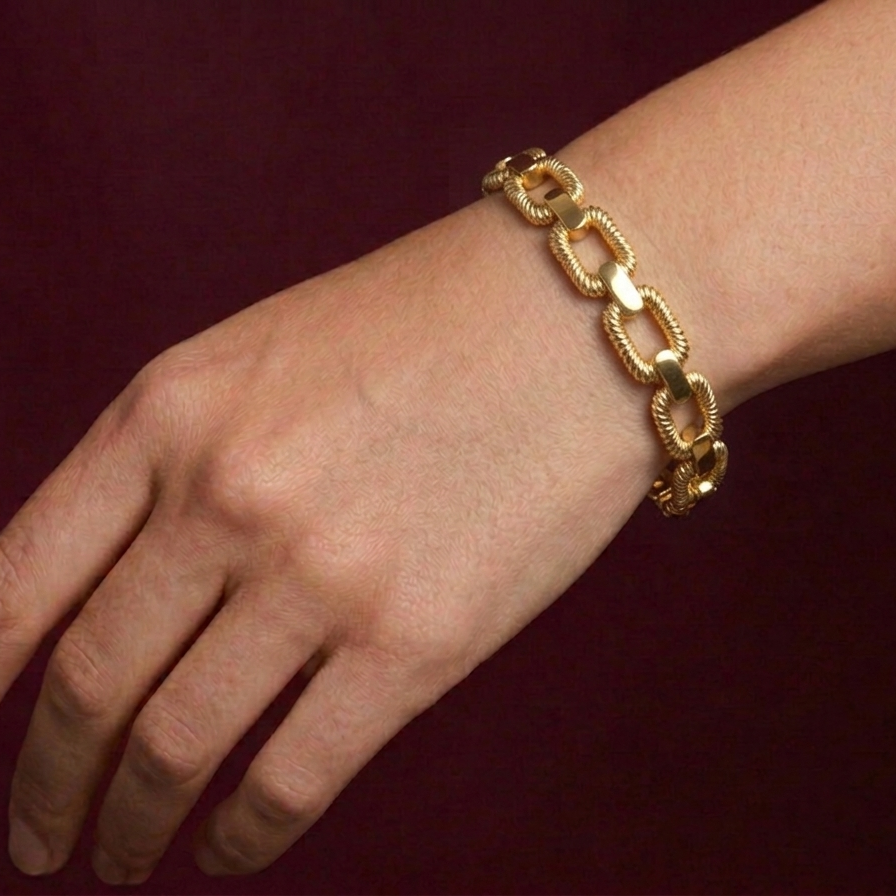 Gold butterfly bracelet on a wrist against a dark background