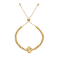 Gold beaded bracelet with a clover-shaped charm on a white background
