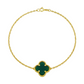 Gold bracelet with a green clover-shaped clasp on a white background