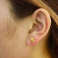 Woman wearing gold flower stud earring, close-up on ear, elegant gold jewelry