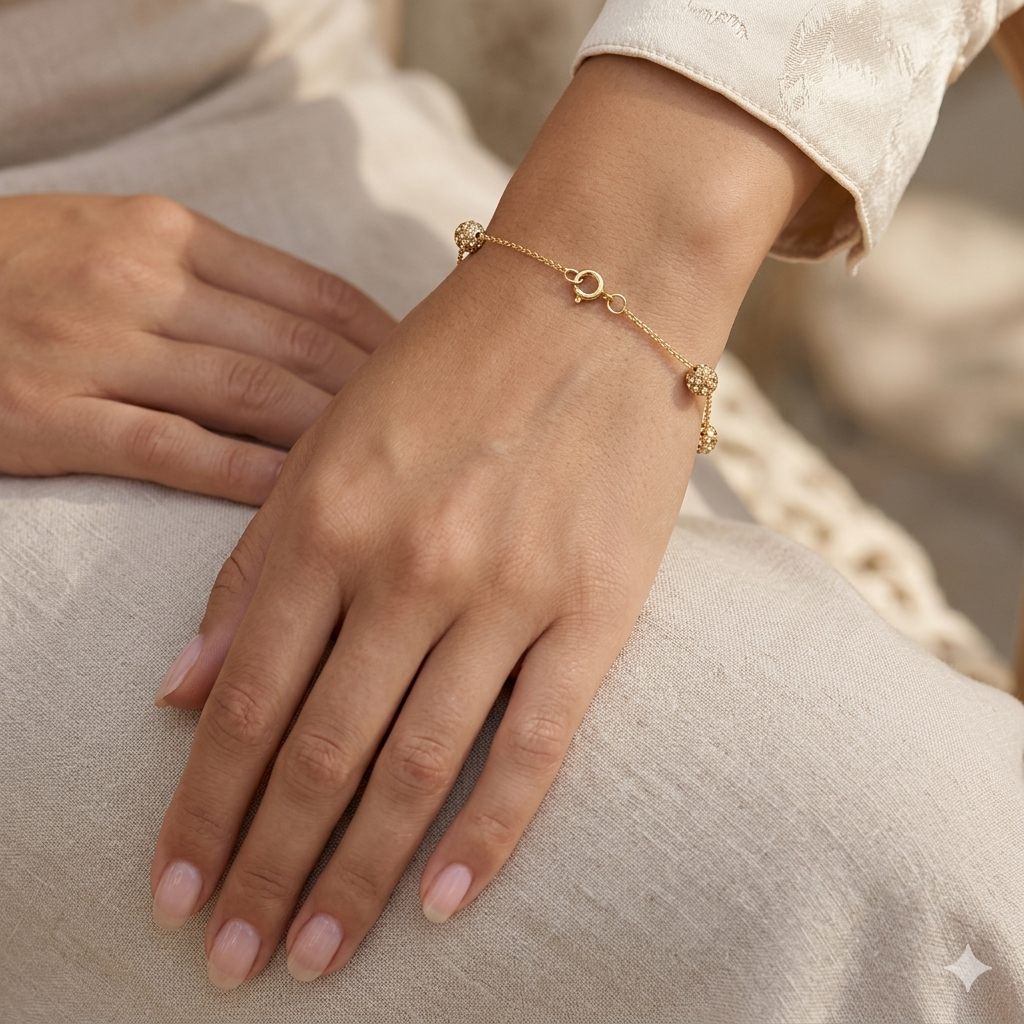 Gold bracelet on a person's wrist with a neutral background