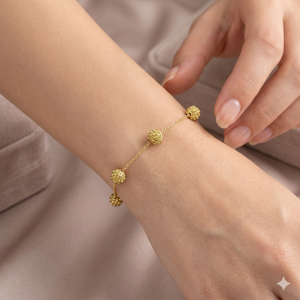 Gold bracelet on a wrist with a neutral background