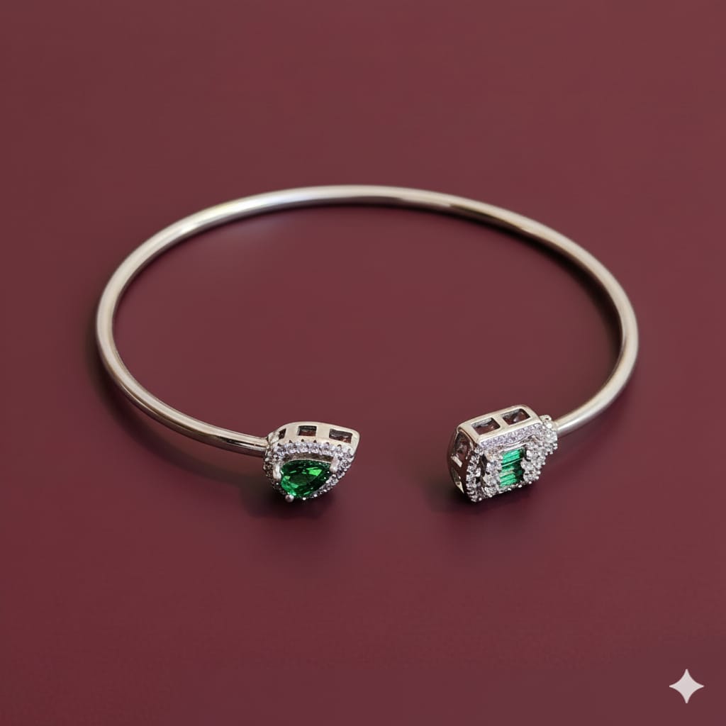 Silver bracelet with green gemstones on a maroon background