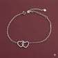 Silver bracelet with heart designs on a maroon background