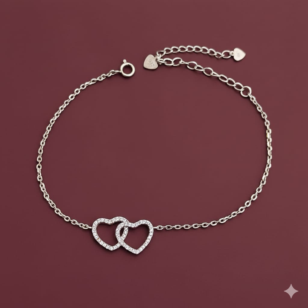 Silver bracelet with heart designs on a maroon background