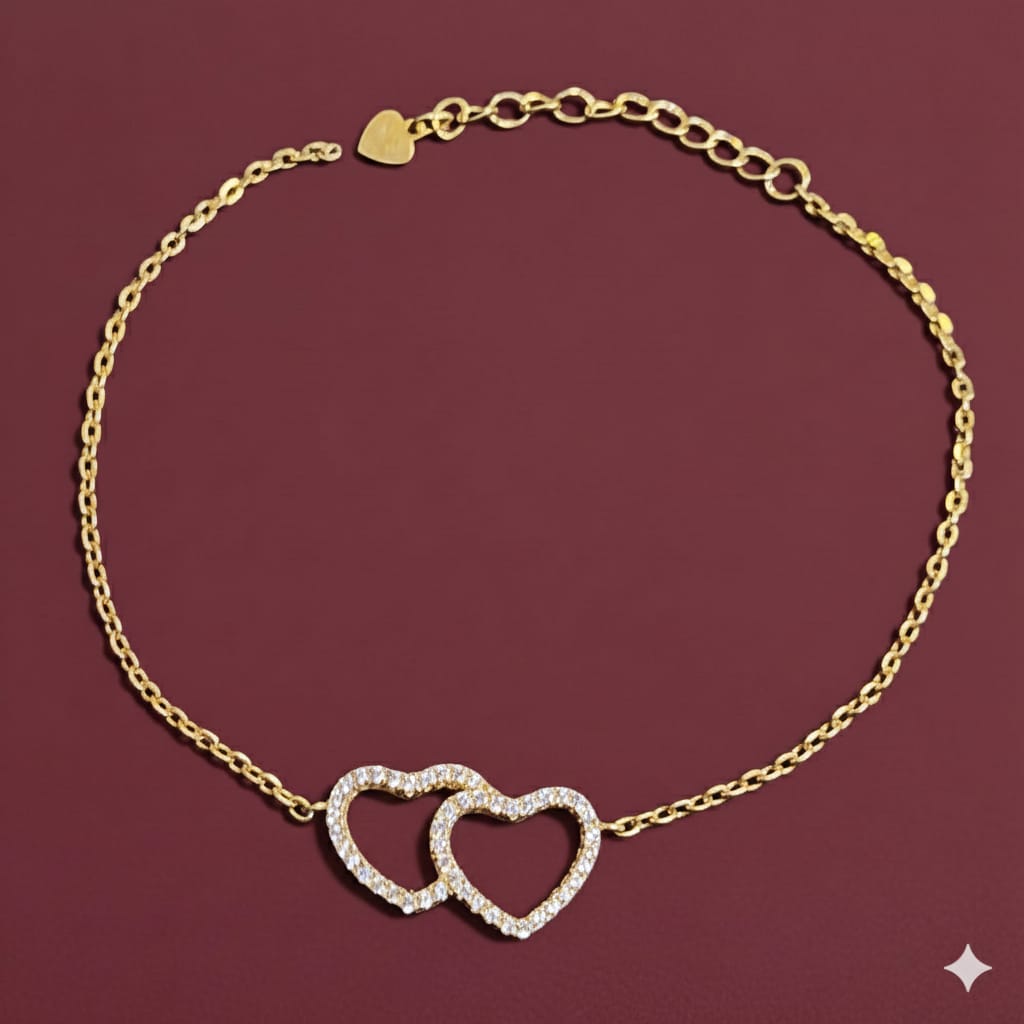 Gold bracelet with interlocking heart charms on a red background