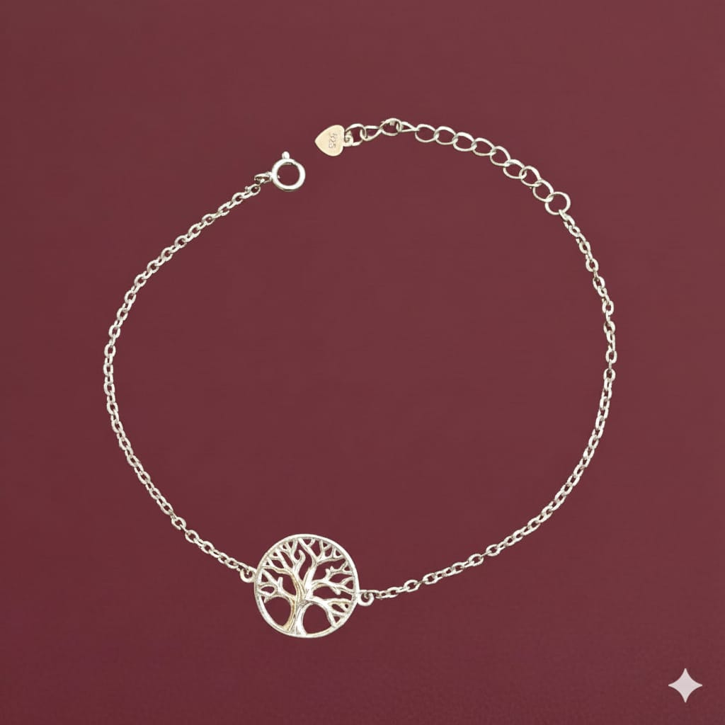 Silver bracelet with a tree of life design on a maroon background