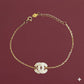 Gold bracelet with a diamond-studded clasp on a maroon background