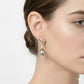 Pearl earring worn by a model on a plain background