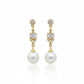 Gold earrings with pearls and gemstones on a white background