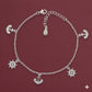 Silver bracelet with anchor and wheel charms on a red background