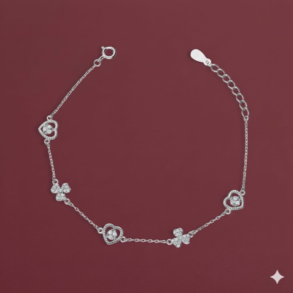 Silver bracelet with floral designs on a maroon background