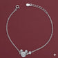 Silver bracelet with a decorative clasp on a maroon background