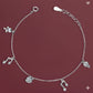 Silver bracelet with charms on a maroon background