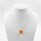 Necklace with a heart-shaped orange pendant on a mannequin bust against a white background
