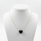 Necklace with a black heart-shaped pendant on a mannequin bust against a white background