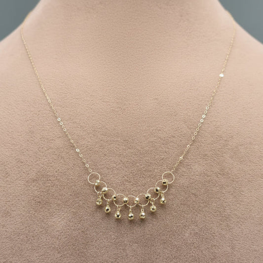 Gold necklace with small beads on a mannequin, close-up inset showing necklace details.