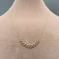 Gold necklace on a mannequin neck against a neutral background