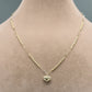 Gold heart-shaped pendant necklace on a mannequin with a neutral background