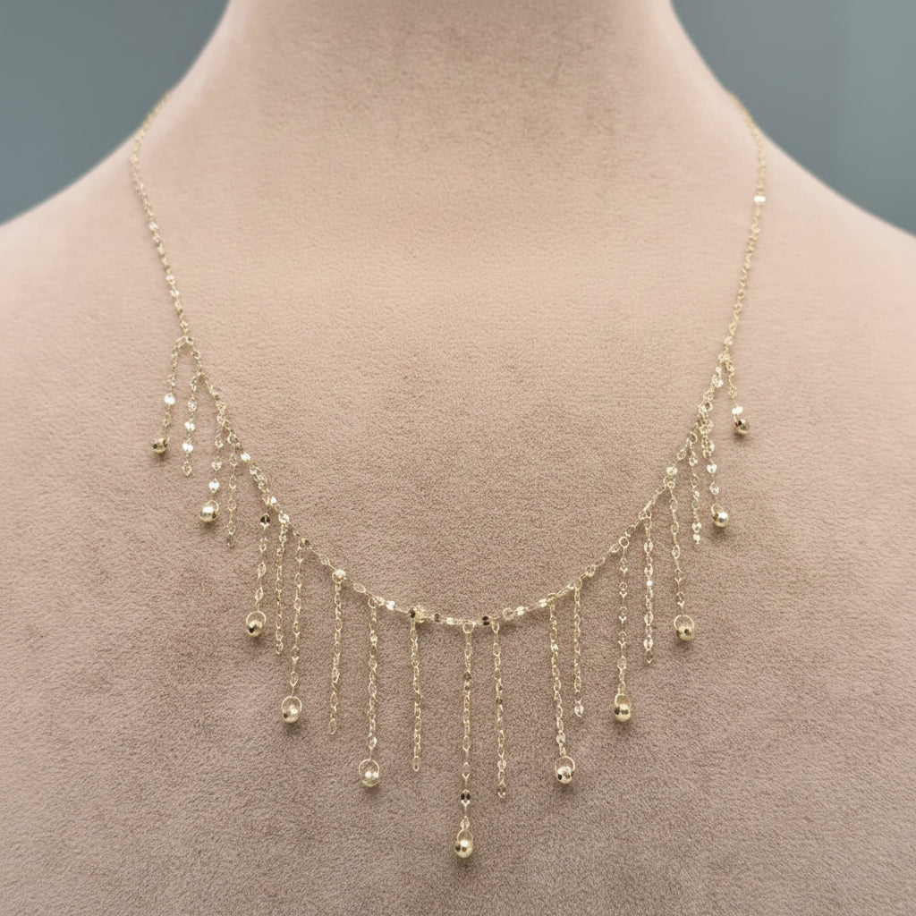 Delicate gold necklace on a mannequin with a neutral background