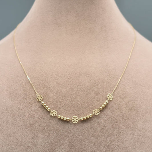 Gold necklace with floral designs on a mannequin neck, showing weight and code.