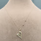 Silver heart-shaped necklace on a mannequin with weight and code information.