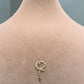 Gold necklace with a key pendant on a mannequin neck, labeled with weight and code.