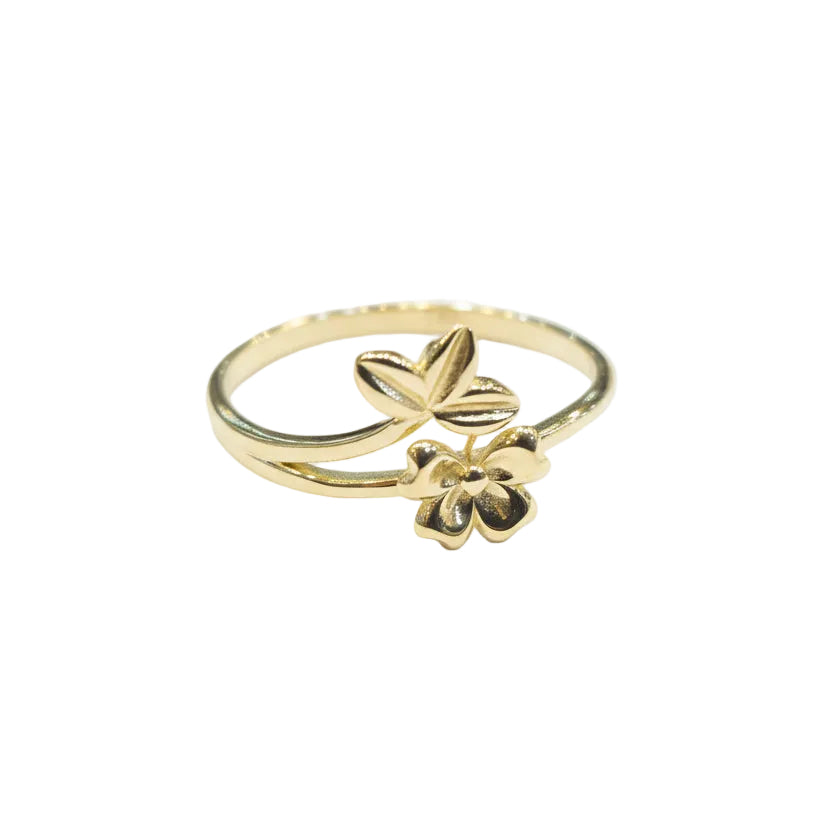 Gold ring with floral design on a gray background