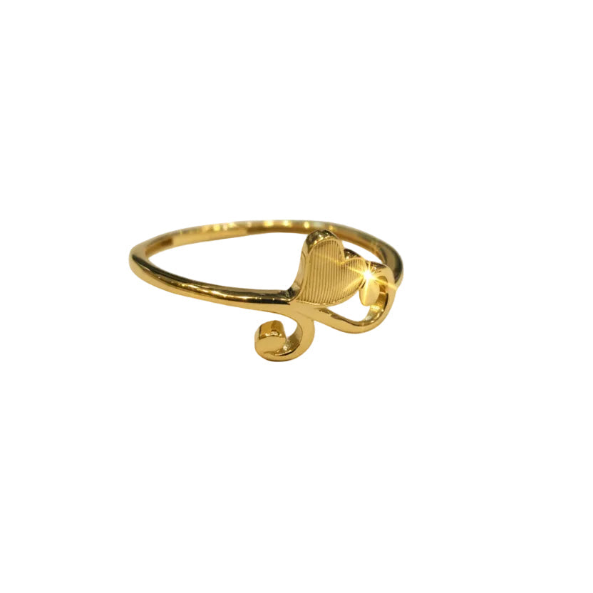 Gold ring with heart design on a gray background