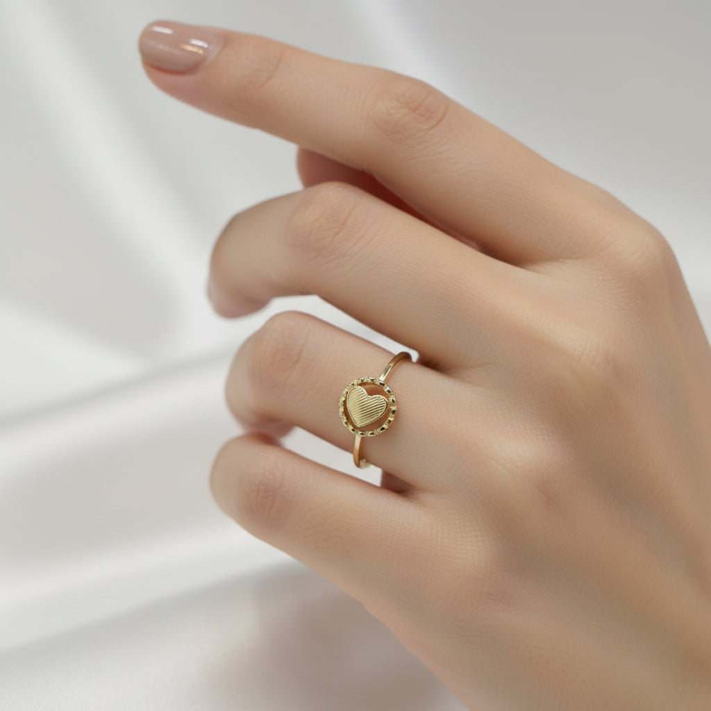 Gold ring with a heart design on a gray background