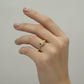 Gold ring with leaf design on a gray background
