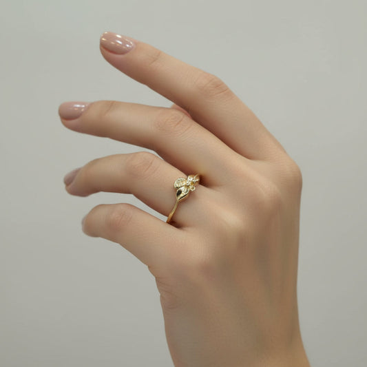 Gold ring with leaf design on a gray background