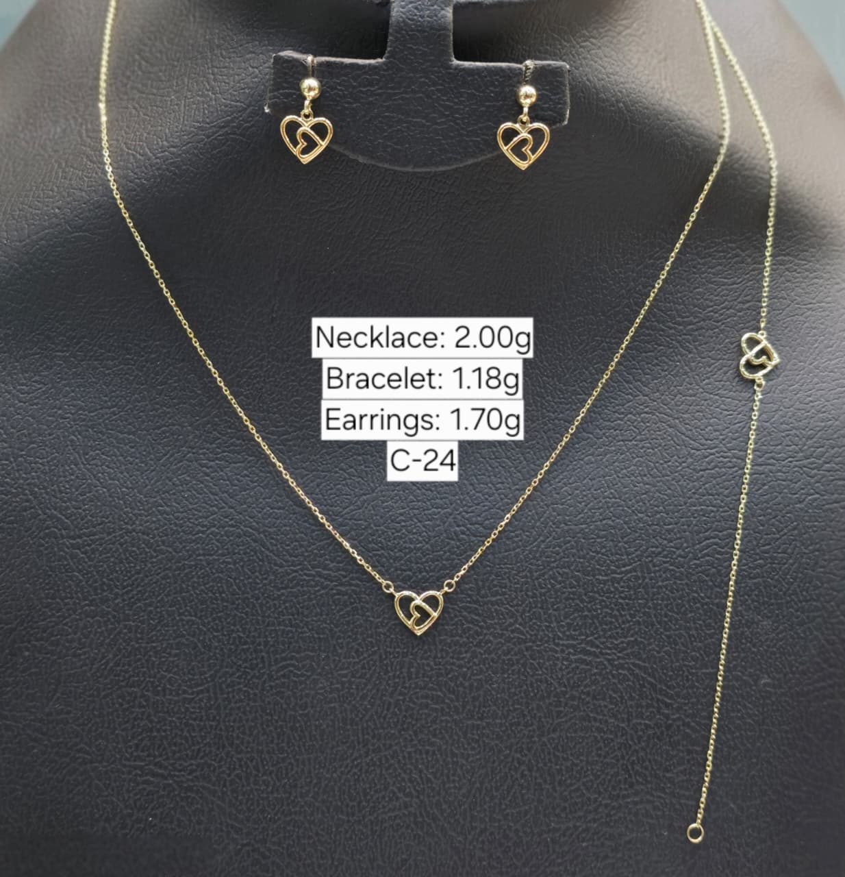 Gold necklace, bracelet, and earrings on a black background with weight labels.