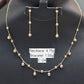 Gold necklace and earrings on a black stand with weight labels.